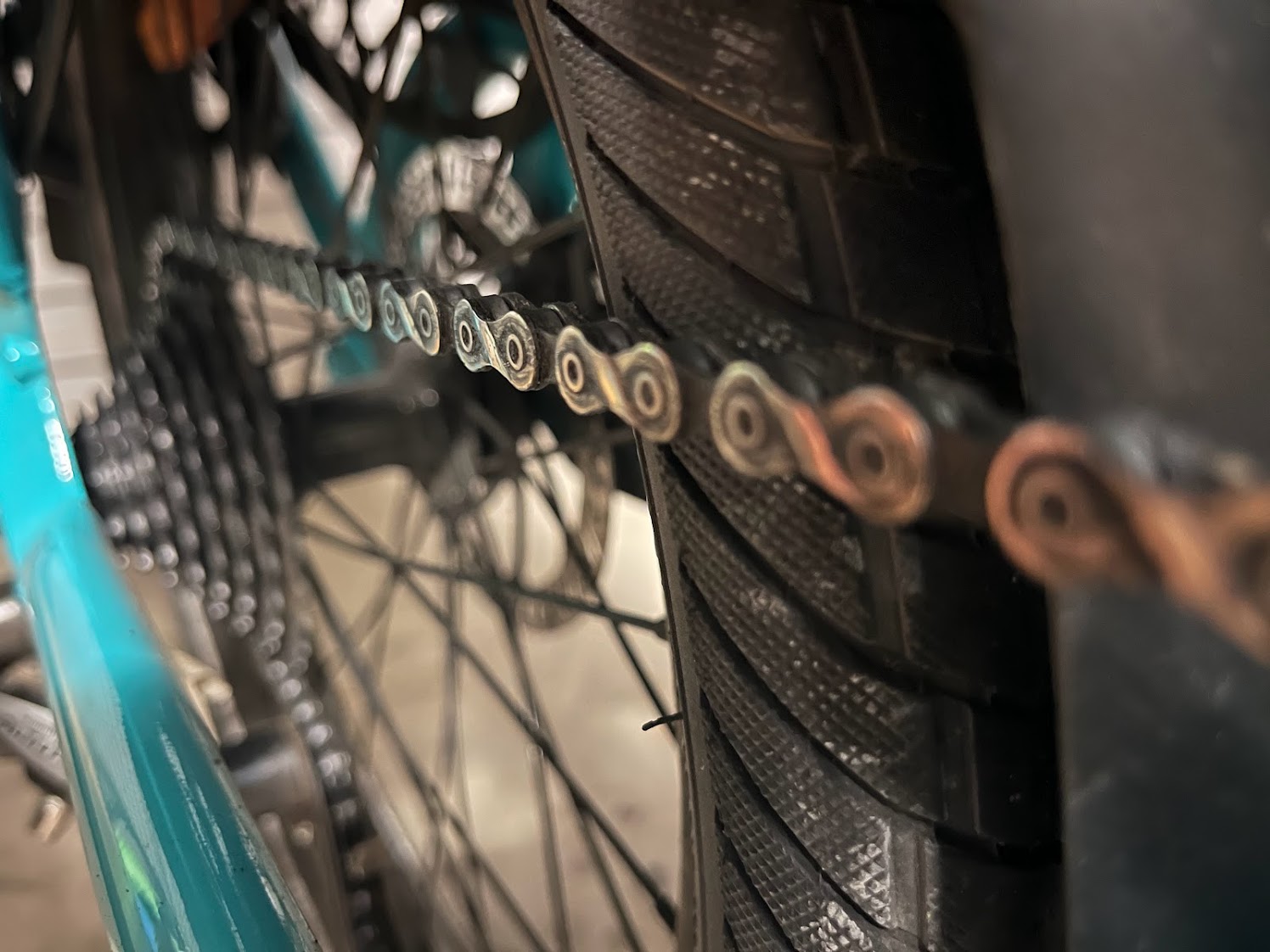 The chain of the Evamos foreground running up against the tyre. In the background, the chain is on the largest cog on the cassette.