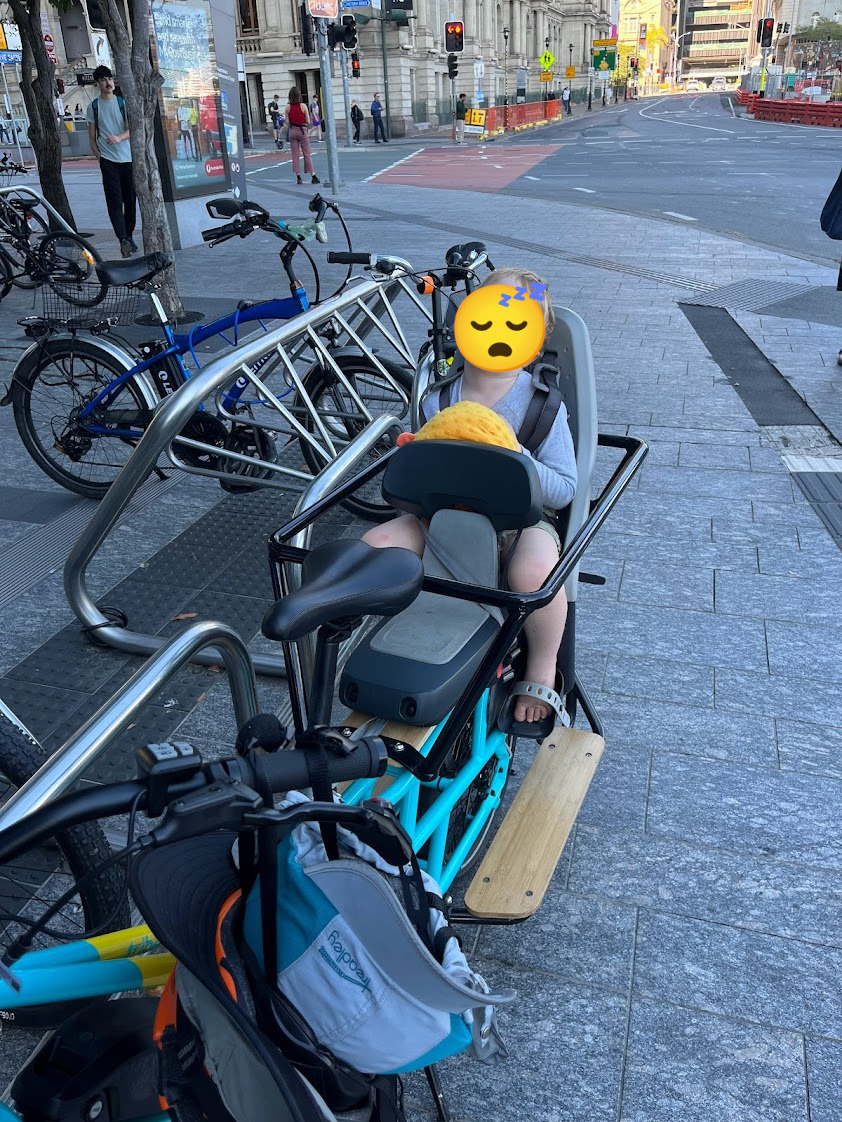 My youngest son, asleep in the rear seat of the evamos. Parked in the city.